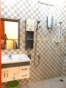 a bathroom with a shower with a sink and a mirror at Leng Seng Na Hotel in Battambang