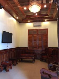 a living room with a flat screen tv and chairs at Leng Seng Na Hotel in Battambang