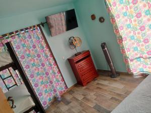 Cette chambre comprend deux rideaux et une télévision murale. dans l'établissement Casa orquídea, à Oacalco