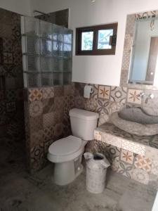 La salle de bains est pourvue de toilettes, d'un lavabo et d'une baignoire. dans l'établissement Casa orquídea, à Oacalco