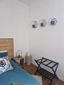 - une chambre avec un lit et 3 sphères sur le mur dans l'établissement Les Minimes, à Issoudun