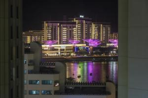 - une vue sur la ville la nuit avec des lumières violettes dans l'établissement Livbnb- Homely 3+1 in Heart of JBR, Close to Beach, à Dubaï