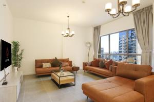 un soggiorno con 2 divani e una TV di Livbnb- Homely 3+1 in Heart of JBR, Close to Beach a Dubai