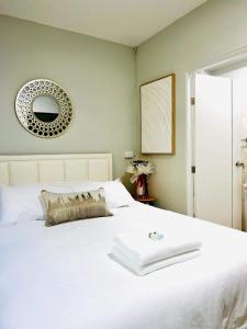 a bedroom with a white bed with a mirror on the wall at Luna hotel สถานีดอนเมือง in Ban Don Muang