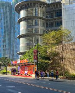 a building with people walking in front of it at L1 Twin Bed Staycation in Bonifacio Global City 4 in Manila