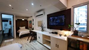 uma sala de estar com televisão e um quarto com cama em L1 Twin Bed Staycation in Bonifacio Global City 4 em Manilla
