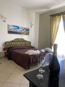a bedroom with a bed and a bottle of wine on a table at Regalpetra Hotel in Racalmuto