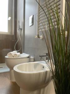 e bagno con vasca, servizi igienici e pianta. di Maioliche Apartments a Margherita di Savoia