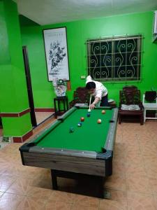 Een man die biljart speelt op een pooltafel. bij Greenhouse homestay betong in Betong