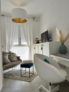 - un salon blanc avec une chaise et un canapé dans l'établissement DOMUSDONA, à Grottammare