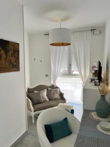 - un salon avec un canapé et une chaise dans l'établissement DOMUSDONA, à Grottammare