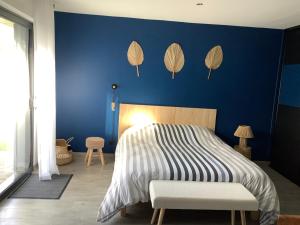 ein blaues Schlafzimmer mit einem Bett und einer blauen Wand in der Unterkunft Le Caux ´Sy in Senneville-sur-Fécamp