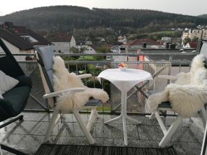 two chairs and a table on a balcony with a view at Ferienwohnung Ruheoase in Bad Kissingen