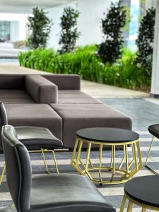 een salontafel, 2 stoelen en een bank bij Stylish Urban Suites Georgetown Sea View in Jelutong
