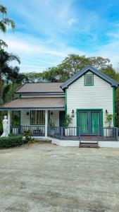 Casa blanca con puertas verdes y patio en Dara Express Inn by Angkor Green Gardens, en Phumĭ Thnál