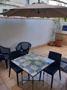 薩雷諾的住宿－SALERNO HOME STATION，庭院内桌椅和遮阳伞