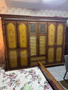 een kamer met een grote houten kast en een bed bij العين الهيلي مصباح ب 5 in Al Ain