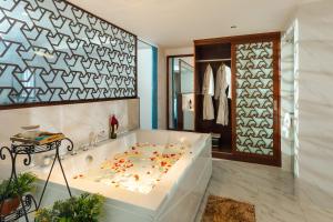 a bathroom with a tub with flowers on the floor at TND Hotel in Nha Trang