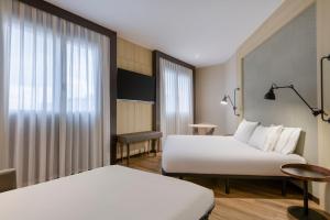 バレンシアにあるAC Hotel Valencia by Marriottのベッド2台と窓が備わるホテルルームです。