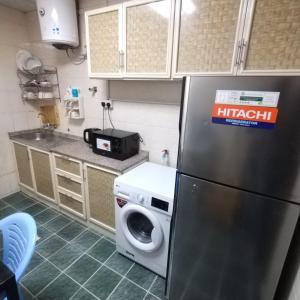 een keuken met een wasmachine en een koelkast bij العين الهيلي مصباح ب 5 in Al Ain