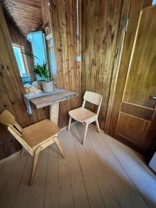 a wooden room with a chair and a table and a window at Vila Strėva in Kozelkiskes