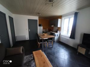 uma sala de estar com uma mesa e uma cozinha em Logement au coeur de l'Auvergne em Lorlanges