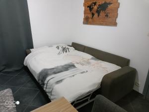 a bed with a white blanket on it in a room at Logement au coeur de l'Auvergne in Lorlanges
