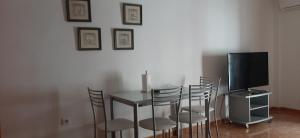 a dining room with a table with chairs and a television at Carboneras, maravillate de su paraiso natural in Carboneras
