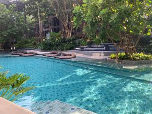 a swimming pool in the middle of a building with trees at The base central phuket in Phuket
