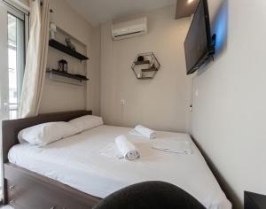 a small bedroom with a bed with a television on the wall at BedCity Apartment with Free Parking in the City Center in Thessaloniki +24 photos