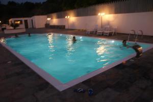 a group of people in a swimming pool at night at BLOOM in Tropea