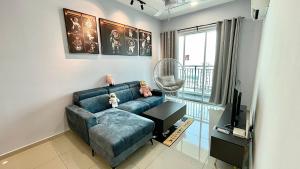 a living room with a blue couch and a television at De Luma-Metropol 3Bedrooms in Bukit Mertajam