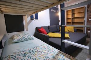 Litera y sofá en una habitación en L'Atelier 57 - Votre meublé authentique !, en Arbois