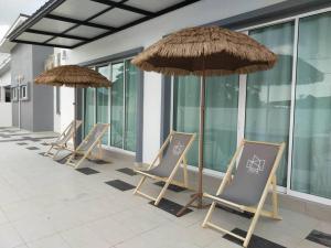 a row of chairs and umbrellas on a patio at Evening/Night de Ville-50pax Private Pool BBQ in Ipoh