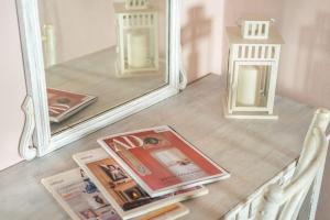 een spiegel met een stapel tijdschriften op een tafel bij Casa Serena in Vicopisano