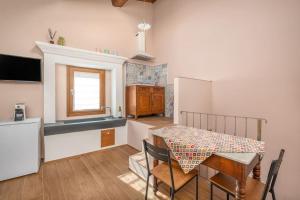 eine Küche und ein Esszimmer mit einem Tisch und einem Kühlschrank in der Unterkunft Casa Serena in Vicopisano
