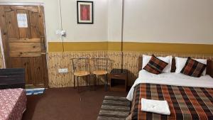 a hotel room with a bed and two chairs at Sweet Rooms near Police Bazar in Shillong