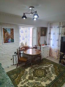 een eetkamer met een tafel en een tapijt bij Лофт в морском стиле in Öskemen