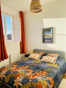 a bedroom with a bed with a colorful comforter at Appartement L'eau vive in Narbonne