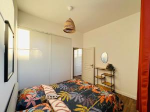 a bedroom with a bed with a colorful blanket at Appartement L'eau vive in Narbonne