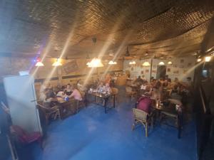 un gruppo di persone seduti ai tavoli in un ristorante di Roomy Guesthouse a Koh Rong Island