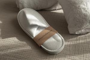 un zapato con una etiqueta sentado en una cama en Albades Hotel & Spa - Adults Only, en Benicàssim