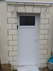 a white garage door with a window on a brick wall at Studio neuf des amandines in Pont-Sainte-Maxence