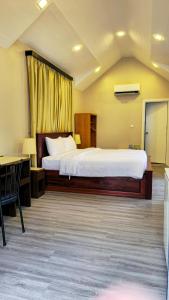 1 dormitorio con 1 cama y escritorio en una habitación en Dara Express Inn by Angkor Green Gardens, en Phumĭ Thnál