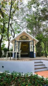 Cette petite maison dispose d'une terrasse couverte, d'une table et de chaises. dans l'établissement Dara Express Inn by Angkor Green Gardens, à Phumĭ Thnál