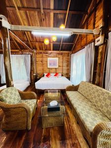 un soggiorno con un letto e due divani di บ้านสวนแก้วคำแพง Baan Suan Kaew Khampaeng a Udon Thani