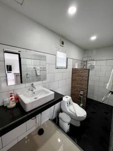 La salle de bains est pourvue d'un lavabo et de toilettes. dans l'établissement The Wok Tum Manor!, à Ko Pha Ngan