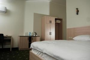a bedroom with a bed and a wooden cabinet at Colette Hotel in Yerevan