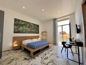 a bedroom with a bed and a desk and a window at Hotel Exclusive in Agrigento