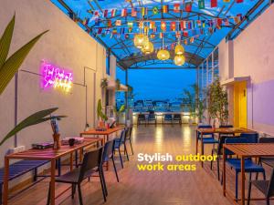 a restaurant with tables and chairs and a view of the ocean at The Hosteller Bangalore, Koramangala in Bangalore